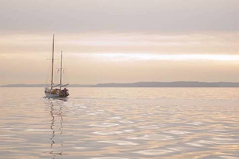 Ketch motoring on silver water